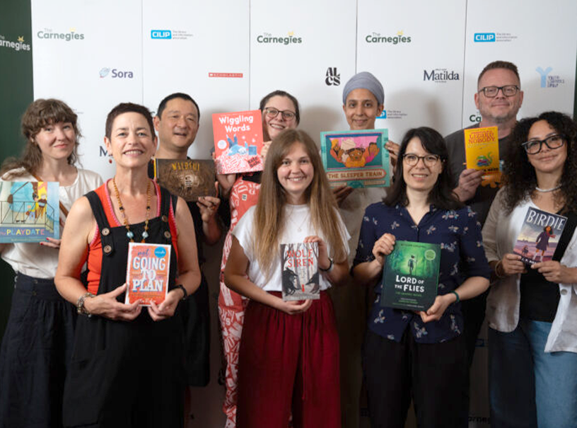 Shortlistees for the 2026 Carnegies pose with their books. Photo by Tom Pilston 